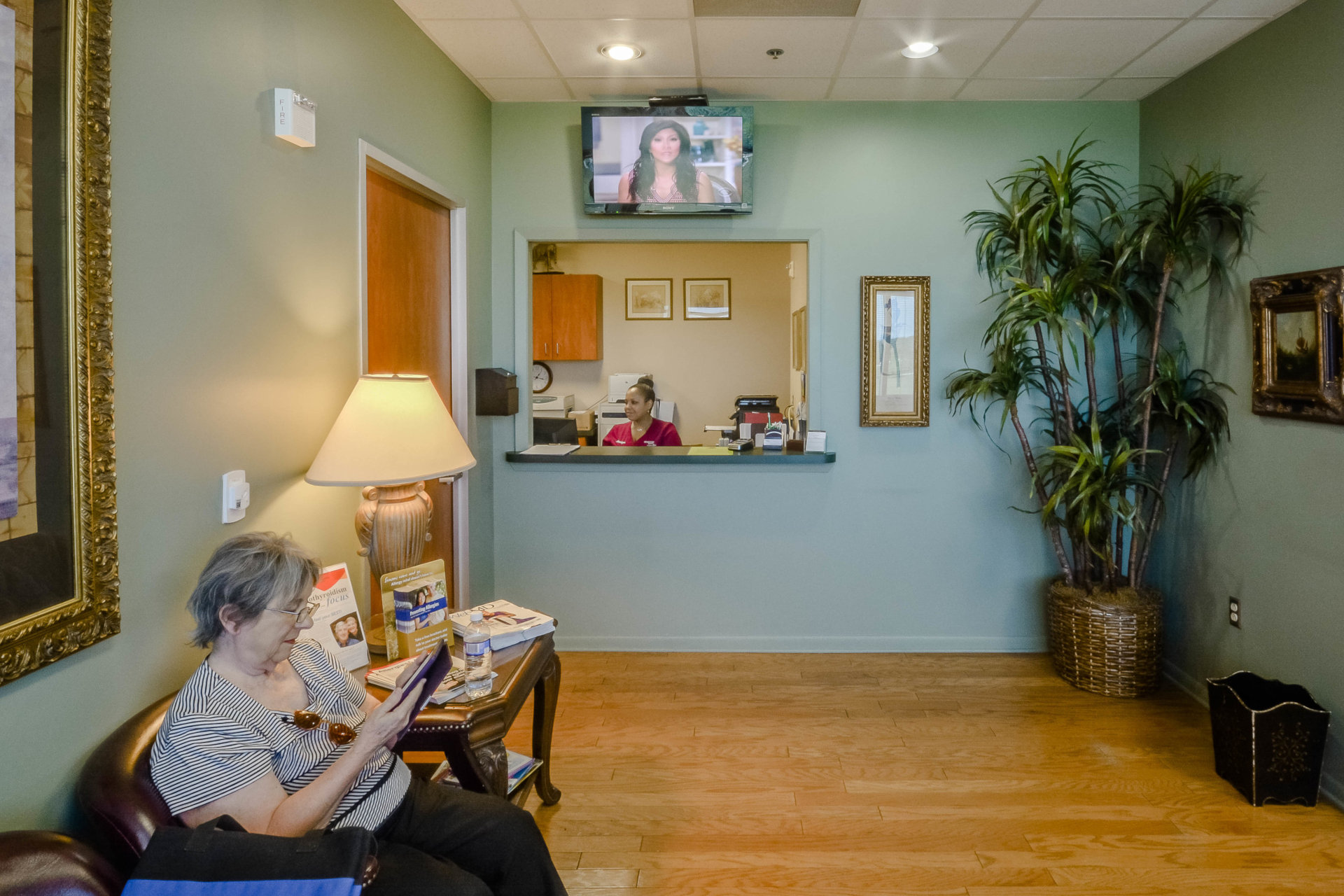 Waiting room at Audible Hearing Centers with woman reading in chair